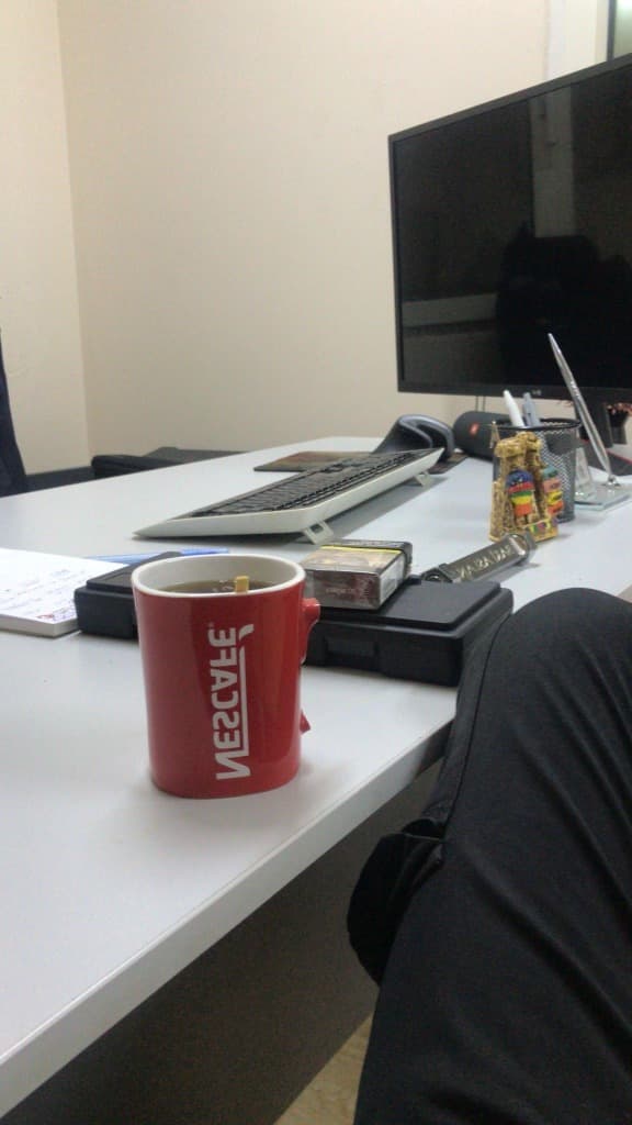 Fresh coffee in a white mug on an office desk